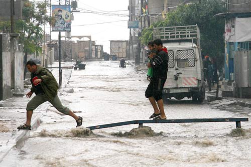 This image shows two persons in storm water filled streets