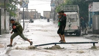 This image shows two persons in storm water filled streets